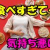 食べすぎて気持ち悪そうに床に横たわる人と周囲に並ぶハンバーガーやスイーツなどの食べ物