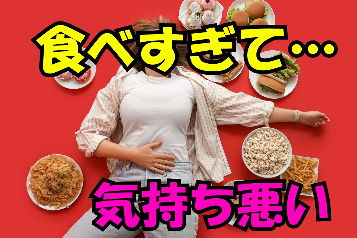 食べすぎて気持ち悪そうに床に横たわる人と周囲に並ぶハンバーガーやスイーツなどの食べ物