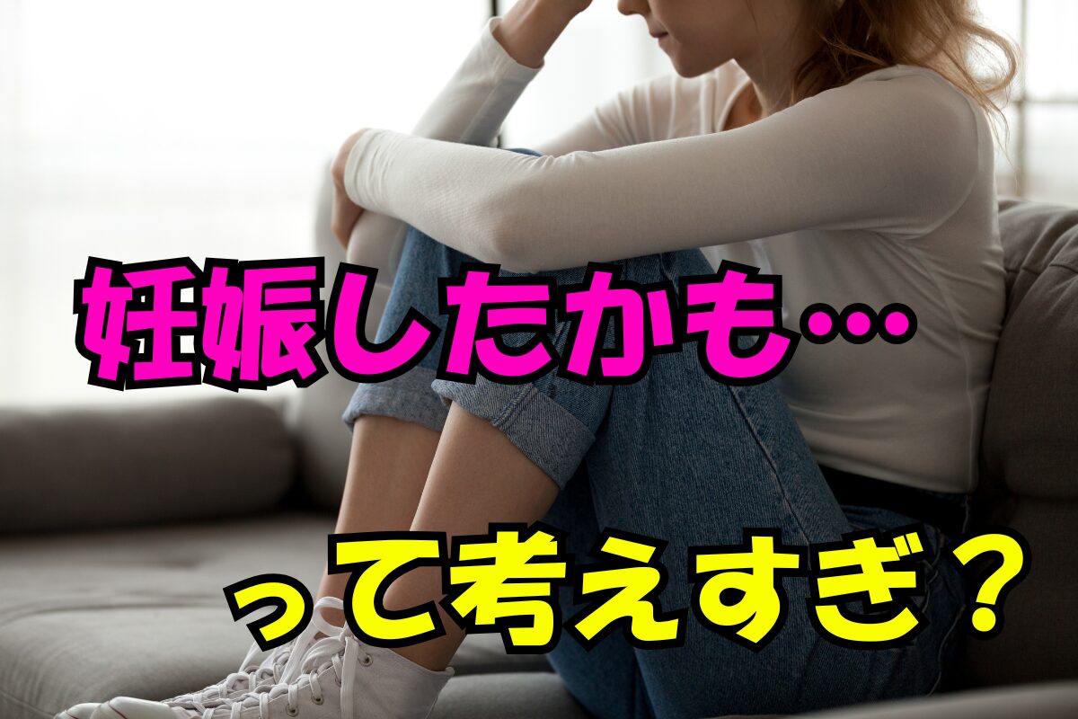 妊娠したかも…と不安で考えすぎている女性のイメージ。ソファに座り、膝を抱えて悩んでいる様子